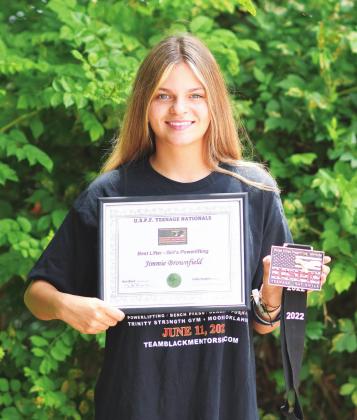 Above, Jimmie Brownfield deadlifting 203 pounds at the U. S. Power Lifting Federation teenage nationals and, right, with her certificate for being best lifter and the medal she won for her division.