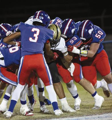 Chandler’s defense dominated Hugo the entire game Friday night, and this photo is a visual metaphor for the Lions’ stifling play. Darius Wade (3), Easton Manning (53), Matt Burris (50), Coniah Ritchie (16), Ty Garver (11) and one unidentifiable Lion on the far side of the play surround and tackle a Hugo ballcarrier. Photo/Brian Blansett
