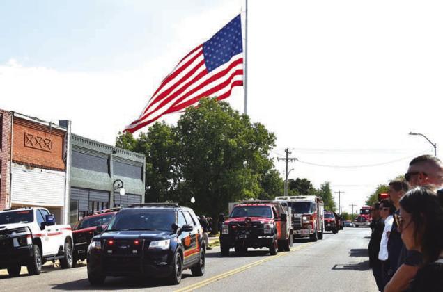 The Wellston and Carney fire departments bring up the end of the funeral procession through Wellston for firefighter Joe Flake on Saturday. First responders from all over the state lined the streets of the town. Photo/Emily Kalka