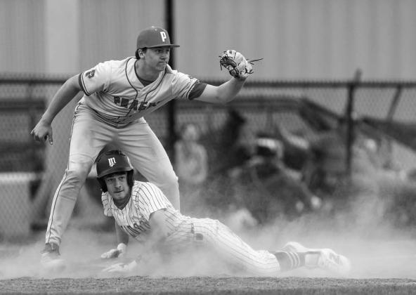 Meeker’s Bryce Bussell and Prague’s Henry Hankins look back toward the field official for call on the third base steal attempt. Photo/Rick Hester
