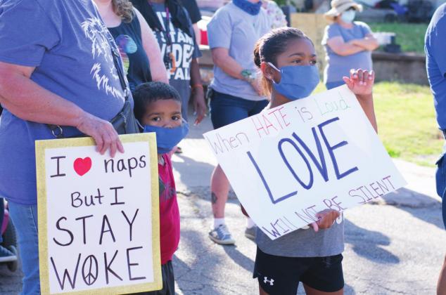 Pictured above, with signs in hands, Chandler citizens walked six blocks to show unification. Photo/Brian Blansett. To the left, Houston Murray and Aubri Murray hold signs during the Unity Walk. Photo/Chelsea Weeks.