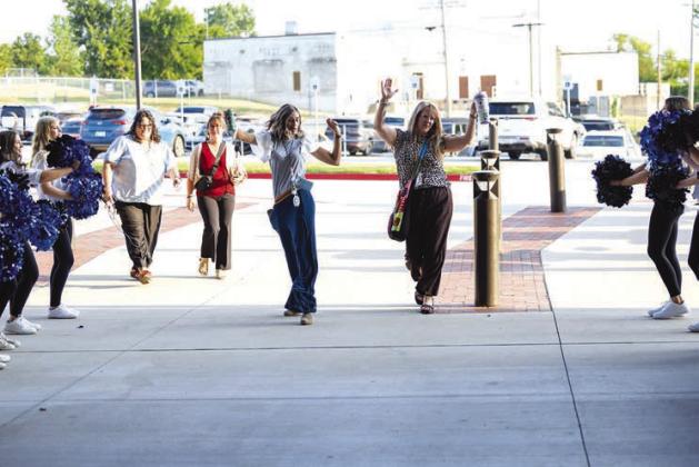 Lacey Echelle and Tonya Pennock, both first grade teachers at Stroud Public Schools, dance their way back to school, cheered on by the pom squad, cheerleaders and marching band on Aug. 3. Photo/Beth Young