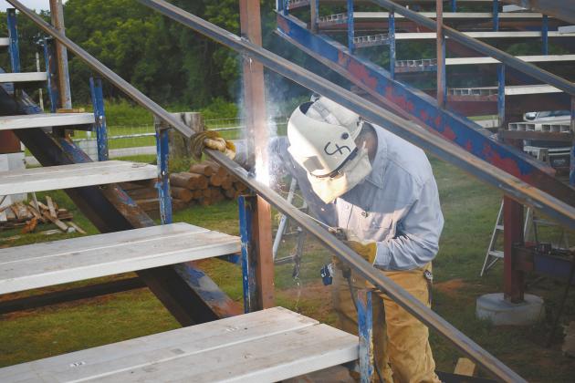 Clu Harkins welds together the guardrails on the new bleachers at the Chandler Round Up Club’s Rodeo Arena. Clu, along with his parents, was part of the team to install both the new bleachers and lights at the arena. Photo/ Emily Kalka