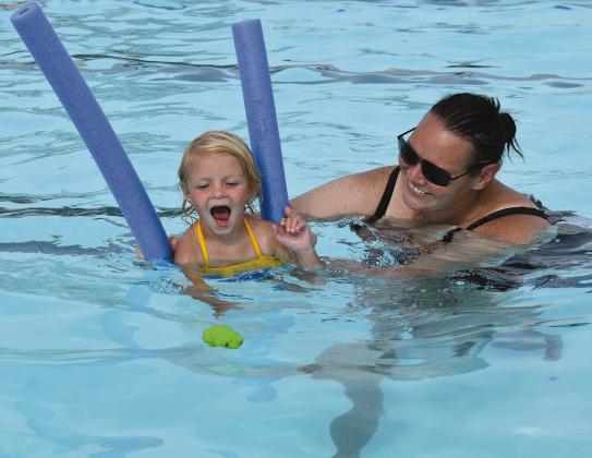 Top photo, from left to right: Addison Hamilton and her mother Dakota, instructor Brandey Fine, Brynne Grill and her mother Ally, Tucker Johnson and his mother Hayley, and Grace Keeth and her mother Patricia take part in a rousing round of “Pop Goes the Weasel” at the Stroud Pool’s new Mommy &amp;amp; Me Swim Class on July 17. Above, Grace works on her doggy paddling skills with her mother Patricia. Photos/Emily Kalka