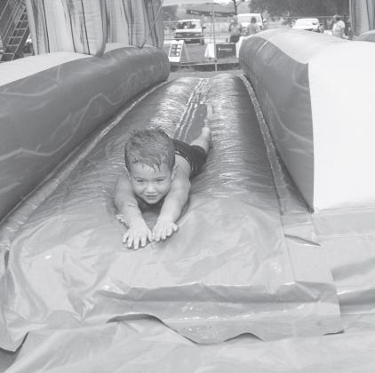 This slide tunnel was one of two water inflatables set up at the Unity in the Community event held at Tilghman Park in Chandler. Here, Chandler second grader Noah, 9 years of age, shows others how to get wet while having fun.