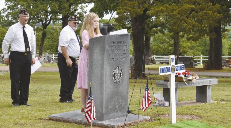 Eighth grader Amelia Riggin reads a poem she wrote at the Memorial Day program on Monday at Oak Park Cemetery. Riggin won the annual poetry contest among seventh- and eighth-grade Pre-AP students at Chandler Junior High. The contest began as a way to select a poem to be read at the ceremony and is sponsored by a member of the American Legion. The judges were veterans. Photo/Emily Kalka