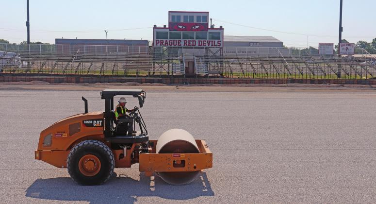 A roller levels and packs gravel where bermuda grass used to grow at the Prague football field. The Red devils are getting new turf on the football, softball and baseball fields. Photo/Stephanie Woolsey