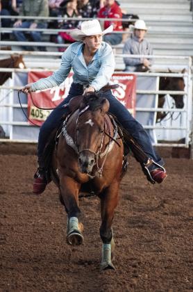 Marley Miller glances at the clock as she heads her horse to the timer line during pole bending competition at the International Finals Youth Rodeo in Shawnee Thursday night. Photo/Brian Blansett