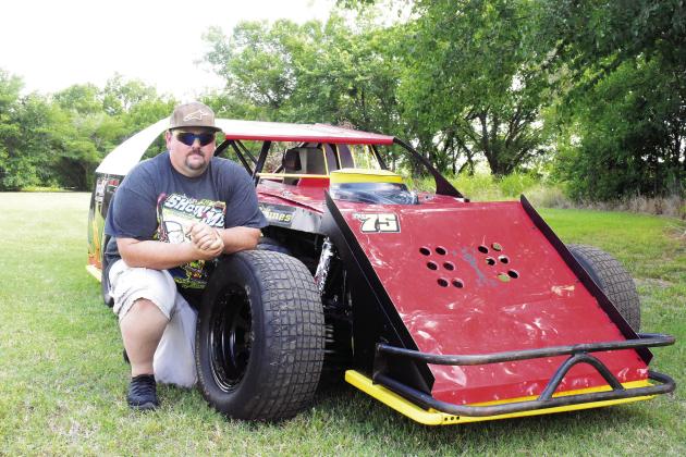 Stephen Grimes, from Meeker, kneels by his sports-modified race car. Photo/Jentezen Smith