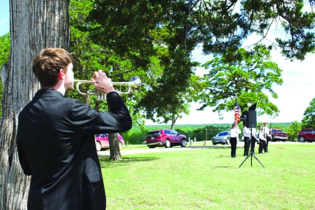 Above, Landon Gray-Pryor plays TAPS at the Chandler Memorial Day Ceremony at Oak Park Cemetery on Memorial Day. Next to that, Jimmie Kalka plants flags at the graves of veterans in New Zion Cemetery on Saturday. Below, Kirk Holloway (left), the chaplain of American Legion Post #64, and Dave Bandell (right), the commander, finish laying a wreath on a representation of the grave of the unknown soldier. Photos/Emily Kalka