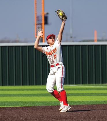 Above, Teague Muncy hits a three-run homer to break the 13-13 tie in the bottom of the seventh for a 16-13 walk-off win in Dale Lady Pirates season opener over Westmoore. Above and on the right, Muncy is greeted at by (L-R) Khloe Jones, Kinley Patten, and Kelbey Welcher after hitting her homer. To the right, second baseman Kaylyn Solis stabs a line drive for an out in their game against Cache. Photos/Rick Hester