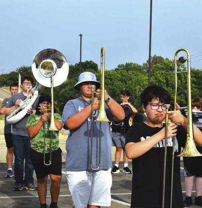 On the left, members of the North Rock Creek marching band work through the basics of marching on Aug. 3 during their band camp. The band’s show this year is “Caged.” On the right, the Spirit of Stroud marching band works through steps at their band camp. The band’s show this year is “Eye of the Hurricane.” Photos/Emily Kalka