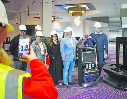 Iowa Tribe of Oklahoma Chairman Jacob Keyes (far right) stands with Harrahs Oklahoma General Manager Joe Scibetta (left of the slot machine) and other members of the Iowa Tribe business committe pose with the first slot machine to be placed at the new Harrah’s Oklahoma Casino. The business is set to open this spring. Photo/Emily Kalka