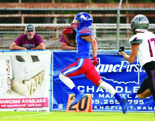 Above, Chace Buchanan flexes as he and his teammates come to the sideline Friday night. Below,Ty Garver goes the distance after catching a swing pass and taking it 62 yards to the end zone. Now 2-2 for the year and 1-0 in district, Chandler faces Metro Christian Friday night in Tulsa. Photo/Brian Blansett