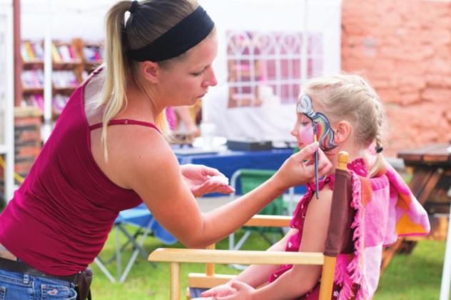 Pictured to the right, Teagan Melton gets her face painted with vibrant colors and glitter.