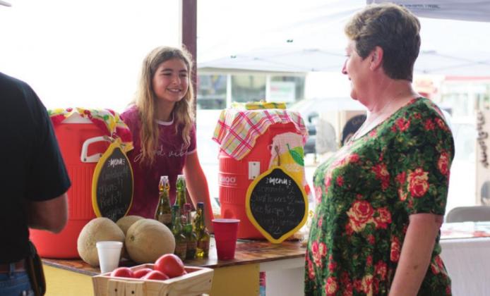 Pictured to the bottom right, Emilia Aldridge smiles to a customer as they check out her lemonade stand. Photos/Chelsea Weeks