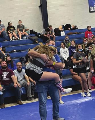 Kalee Peery jumps into the arms of her coach - and dad - Fred Peery after winning the junior high state championship in power lifting. Photo provided