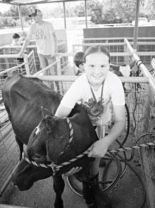 Pictured to the right, Mary Baker washing her heifer before the dairy show. Photo/ Brian Blansett.