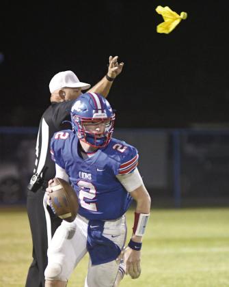 Top, in a visual metaphor for the game, Chandler quarterback Alec Jackson rolls out Friday night against Crossings while the referee throws a flag in the background. Below, Ty Garver (11) makes a fourth-quarter catch despite tight defense from Payton Brady of Crossings. Photos/ Brian Blansett
