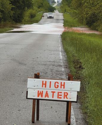 Upper left, vehicles splash through a flooded section of Econtuchka Road just north of the North Candian River in Pottawatomie County and, above, a driver ponders the appropriate move between Davenport and Kendrick. Photos/Brian Blansett