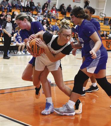 Wellston’s Kamber Goodman (white jersey) wrestles for the ball with Stroud’s Camryn Wilson (left) as Amarie Bobo (right) waits to engage. Photo/Brian Blansett