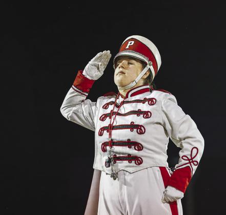 Top, Ronan Martin takes the Senior Night walk at Prague Friday night. Above, drum major Timber Gouker salutes before the band’s halftime performance. Photos/Rick Hester