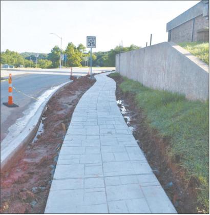 A new sidewalk is installed in front of Chandler City Hall, winding around to the railroad bridge. Despite some setbacks due to rain, the City is moving ahead with building Imel Park -- located behind City Hall -- and renovating Reed Park -- located on Allison. Photo/Emily Kalka