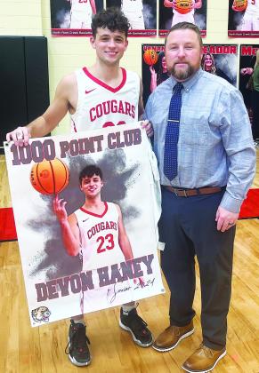 North Rock Creek senior Devon Haney scored the 1,000th point of his career during the Cougars’ win over Bristow during district play Saturday night. With him is coach Evan Smith. Photo/Sheryl Gowin