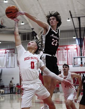Meeker’s Ean Watham (23) gets a hand on a shot by Prague’s J’ohn Friend (0) during the Bulldogs’ 57-53 win Friday night . Both teams will begin the playoffs on the road, with Meeker going to Hennessey for Class 2A on Saturday and Prague heading to Casady on Friday in Class 3A. For more playoff pairings, see Page 2C. Photo/ Brian Blansett