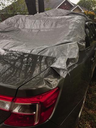 Above, Brent White’s new-to-him car and, right, his old one, shrouded in a tarp after tornado damage.