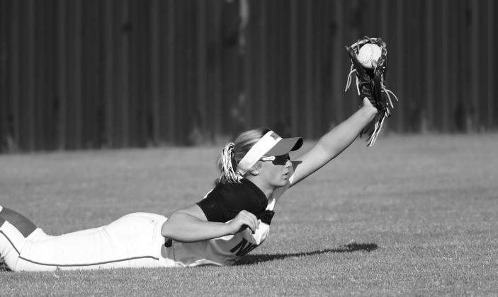 Above, NRC centerfielder Aubree Shivelhood shows the ball after diving for a sinking line drive against Cleveland on Thursday. Below, Carney’s Italy Ventris dives into the third base in the Lady Bulldogs’ come-from-behind win over Glencoe on Tuesday. Photos/Brian Blansett