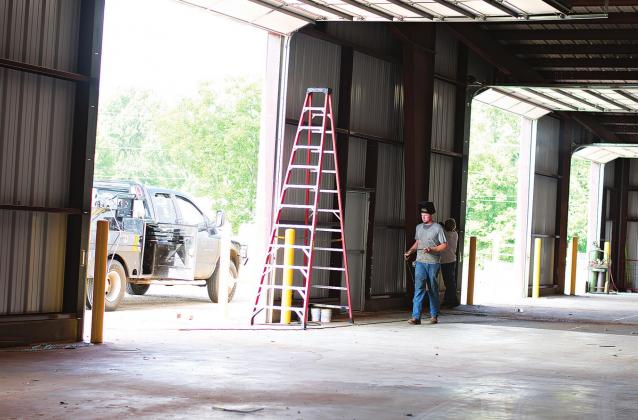Workers with the subcontractor, Fitzgerald Construction, work on the finishing touches on the six overhead doors. Pictured below is the almost completed south wall of the Lincoln County Fairgrounds complex. Photos/Chelsea Weeks