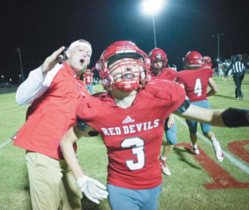 Prague assistant coach Tony Willoughby celebrates with defensive back Aiden Auld in the waning seconds of the Red Devils’ win over Crossings Christian Friday night. Auld intercepted a pass in the end zone to clinch the victory. Photo/Brian Blansett