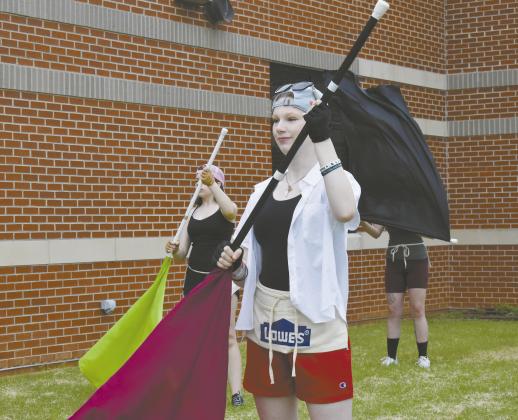 Three members of the colorguard for the North Rock Creek Marching Band practice with their coach on August 1. It was the first week of camp for the band, which plans to add one more competition to their schedule this year. Photo/Emily Kalka