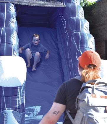 A kid makes his way down a slide at SummerFest. Photo/ Emily Kalka