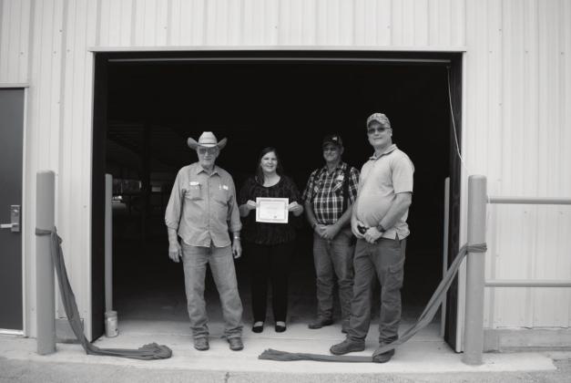 Pictured to the right, from left to right: Troy Evans, Alicia Wagnon, Carl Munson and Lee Doolen stand in the doorway of the newly completed east wall. Photo/Chelsea Weeks.