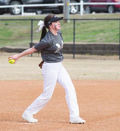 Madison Buoy, above, pitching against Wellston in what turned out to be her last high school softball game and, right, last week working at Anthony’s Grocery in Meeker. Photos/Brian Blansett
