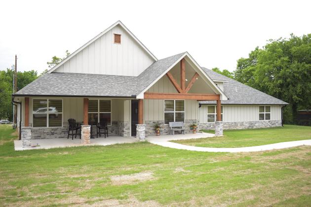 Above left, people gather in the new living room/kitchen of The Chosen House facility at its open house on Saturday. The organization moved from a smaller house to a brand-new home recently. They can now fit up to eight women instead of five. Photo/Emily Kalka