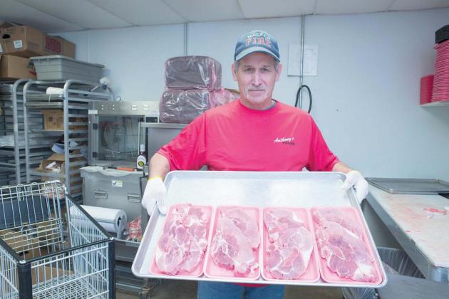 Sheldon Hurst holds packs of beef in the meat market at Anthony’s in Meeker. Photo/Brian Blansett