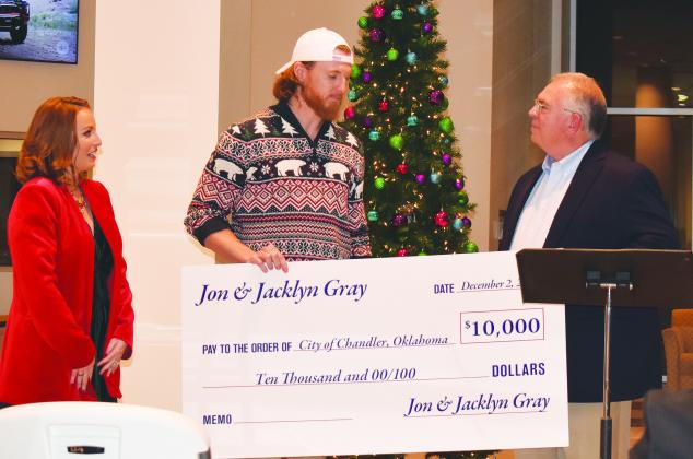 Jon and Jacklyn Gray present Chandler Mayer Kent McVey with a check for $10,000 that the city can use as they wish. The couple made three donations - including to Chandler Athletics and Chandler Schools - on Dec. 2 as a way to show gratitude to the town where they grew up.