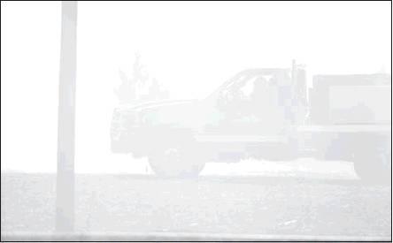 Below, a truck from Sparks is camouflaged by smoke. Bottom, the grass burned up the foundation of the house on the property. Photos/Brian Blansett