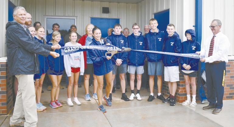 Runner Lexi Martzall cuts the ribbon held up by Superintendent Scott Baade (left) and High School Principal Freddie Hall (right) on the new track facility at Chandler Public Schools. The building contains locker rooms, a coaches’ office and a concession stand. It’s located next to the track and behind the softball field at the high school complex. Photo/ Emily Kalka