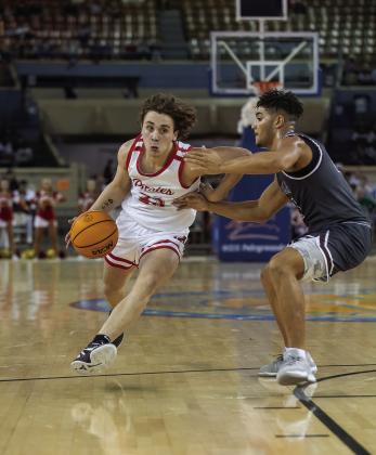 Above, the three-time state champion Dale Pirates pose with the gold ball after the state finals on Saturday. Below, senior Deken Jones drives down the lane. Photos/Rick Hester