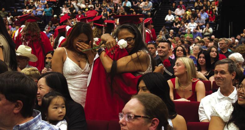 A McLoud grad hugs a family member during the part of the ceremony where the students handed out flowers to mother figures. Photo/Emily Kalka