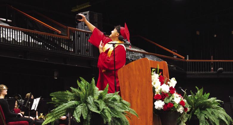 Salutatorian Johnathan Yang takes a selfie at the podium during his speech. Photo/ Emily Kalka