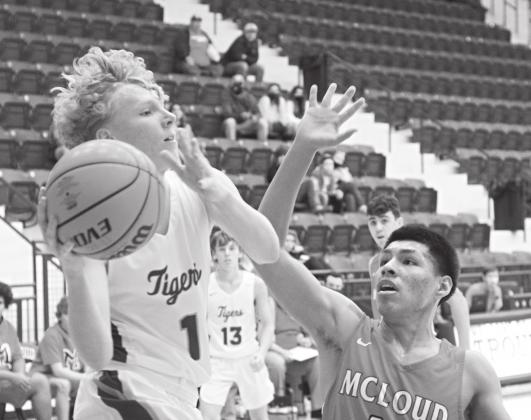 Above, Stroud’s Brice Wolff (1) looks to pass in the lane while McLoud’s Johnny Sparlin defends. Below, Noah McMullan finished with the left hand in North Rock Creek’s win over Crooked Oak. Photos/Brian Blansett