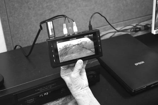 On the left is the full Story Keeper Studio that is available for the public to use at the Chandler Public Library. On the right, Librarian Sandy Tharp-Thee holds up the device that copies videos from VHS or camcorders onto a flash driver. Photos/Emily Kalka