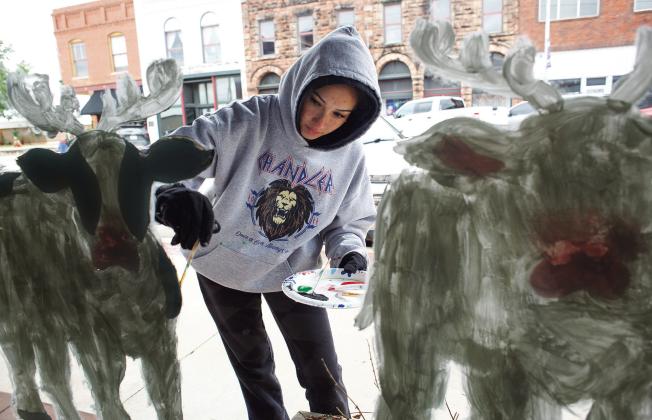Chandler senior Lexi Martzall paints a country Christmas scene on Manvel Avenue. Art students have been decorating windows up and down downtown Chandler since Thanksgiving break. For more information on upcoming Christmas events in Lincoln County, see page 6A. Photo/Brian Blansett