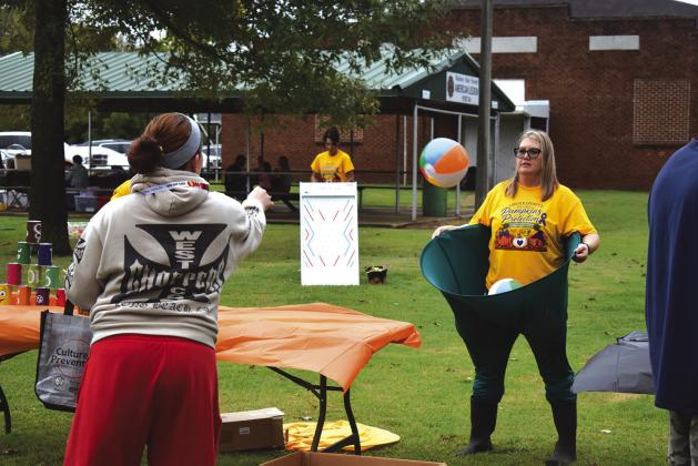 A guest tosses a ball at one of the many game stations at Project SAFE’s Pumpkins for Protection event on Oct. 15. Despite the wind and drizzle, dozens came out to play games, hop in the bounce house and browse through the booths set up by local organziations such as Chandler Dental and the Sac and Fox Nation. Kids showed up in full Halloween gear as well. Photo/Emily Kalka
