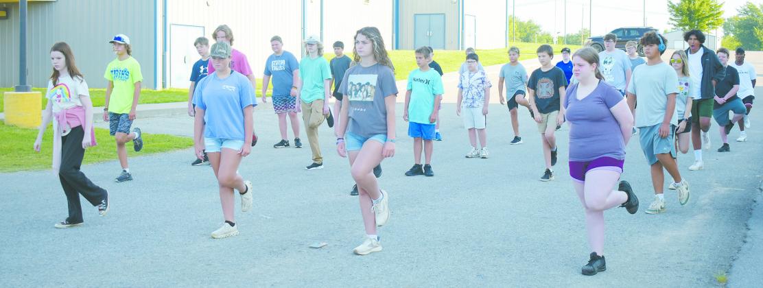 The Pride of Stroud marching band warms up in the parking lot outside of the band room at Stroud High School. The group will be performing an alien invasion-themed program for this year’s show. Photo/Emily Kalka